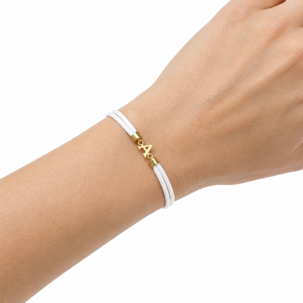 Biala bransoletka z litera A na nadgarstku modelki, biale tlo
